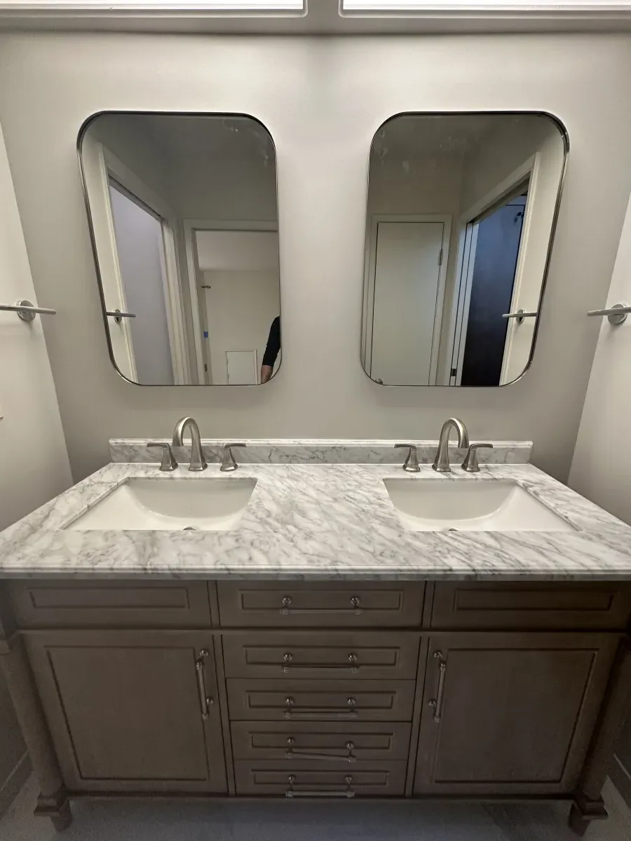 Double vanity bathroom with marble countertop and custom cabinetry