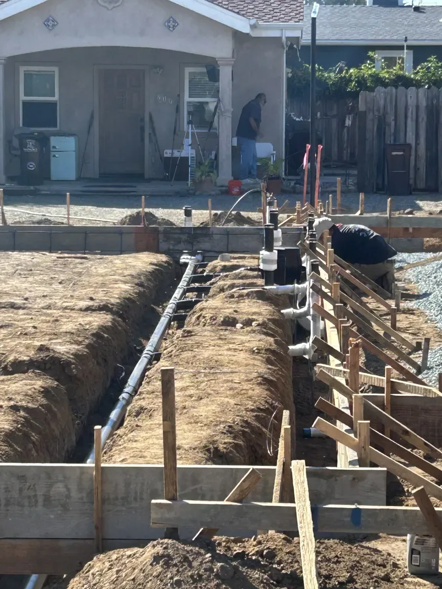 Sewer line installation along foundation for new construction